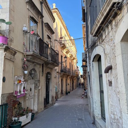View of Ortigia Island with historic waterfront buildings and crystal-clear sea in Syracuse Sicily